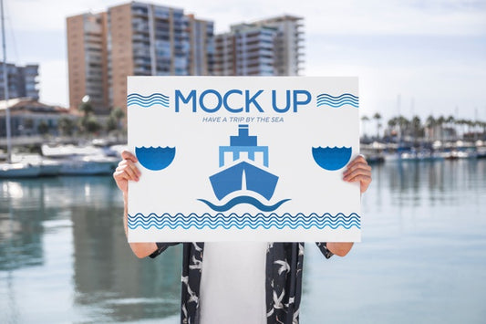 Free Man Presenting Poster Mockup In Front Of Water Psd