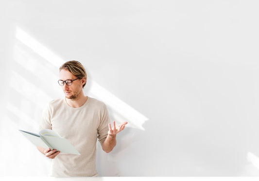 Free Man Reading In Front Of White Wall Psd