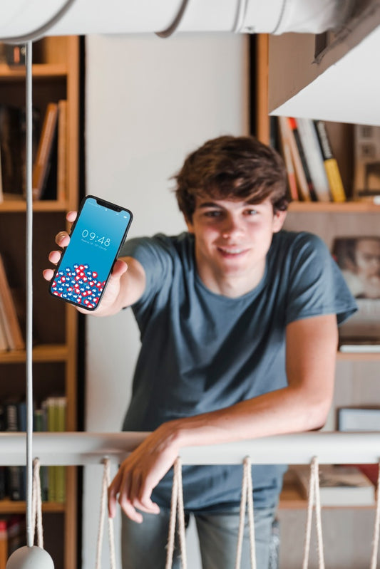 Free Man Showing Smartphone Mockup In Library Psd