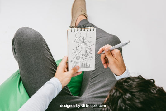 Free Mock Up With Relaxed Man Drawing On The Notebook Psd