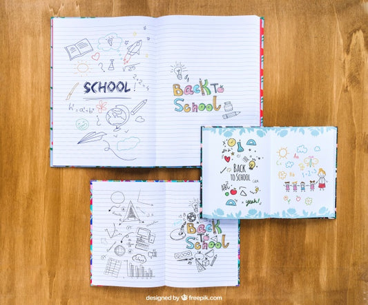 Free Notebooks With Drawings On Wooden Table Psd