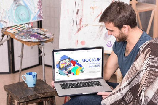 Free Painter Holding A Laptop Digital Mock-Up Psd