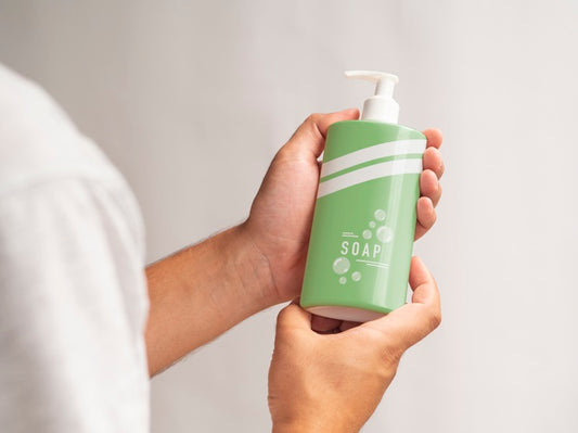 Free Person Holding A Liquid Soap Bottle Mock-Up Psd