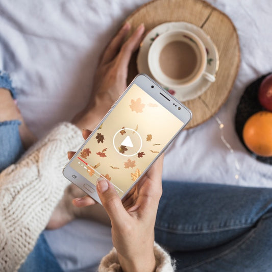 Free Person On Bed Looking At Smartphone With Autumn Concept Psd