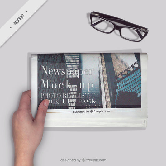 Free Person Reading A Newspaper With A Glasses On The Desktop Psd