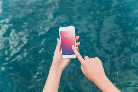 Free Person Using Smartphone Mockup On Sea Background Psd