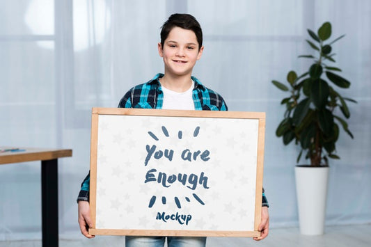 Free Portrait Of Positive Child Holding Mock-Up Sign Psd