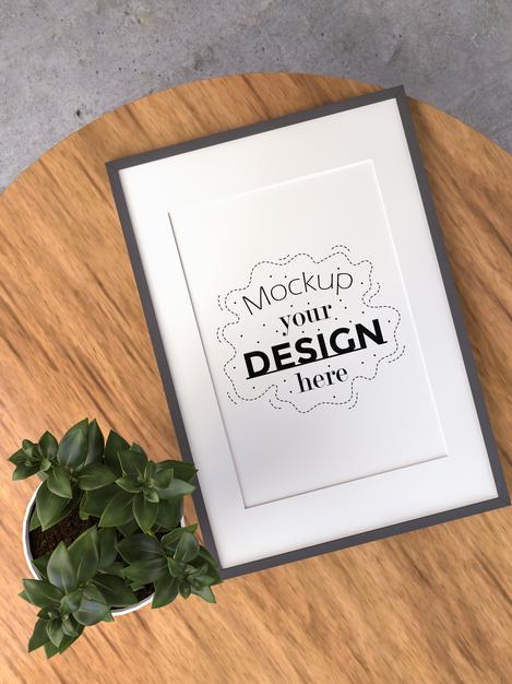 Free Poster Frame Mockup On Wooden Table Psd