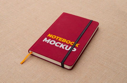 Free Red Notebook On Fabric Surface Mockup Psd