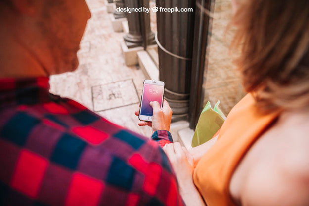 Free Shopping Mockup With Couple Looking At Smartphone Psd