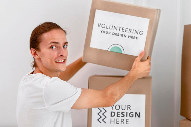 Free Side View Of Male Volunteer Handling Boxes With Donations Psd