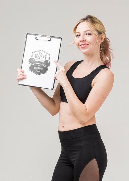 Free Side View Of Smiley Fitness Woman Holding Notepad Psd