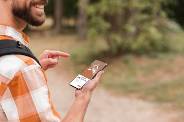 Free Side View Of Smiley Man Holding Smartphone While Camping Psd
