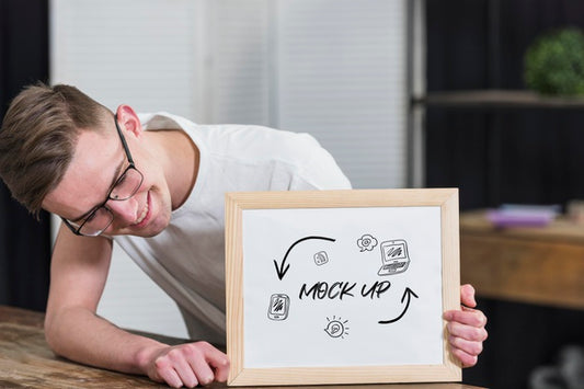 Free Smiley Man With Glasses Holding Mock-Up Frame Psd
