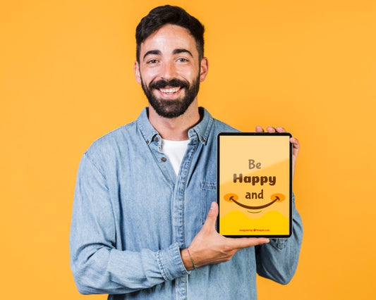 Free Smiling Young Man Holding Tablet Mock Up Psd
