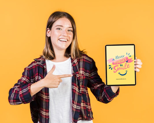 Free Smiling Young Woman Pointing Finger At A Tablet Mock-Up Psd