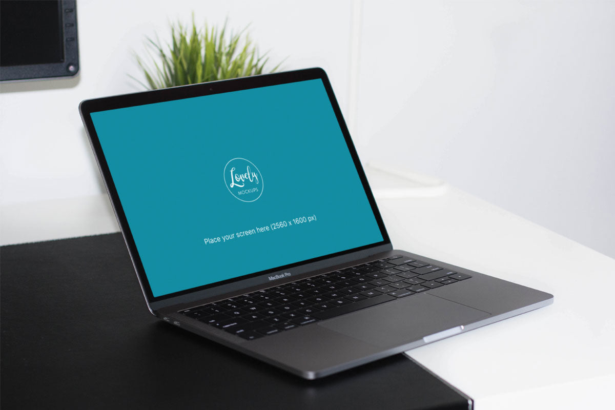 Free Space Gray Macbook on A Table PSD Mockup