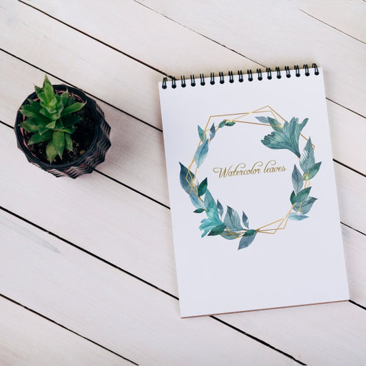 Free Spring Notebook Mockup With Decorative Plant In Top View Psd