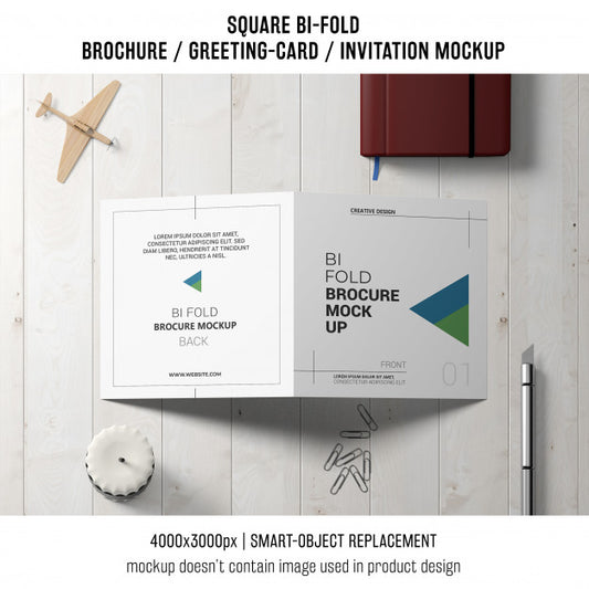 Free Square Bi-Fold Brochure Or Greeting Card Mockup With Decoration On Tabletop Psd