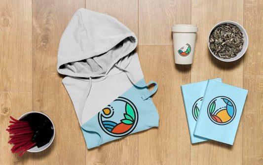 Free Top View Folded Hoodie Mock-Up With Notebooks  And Sunflower Seeds Psd