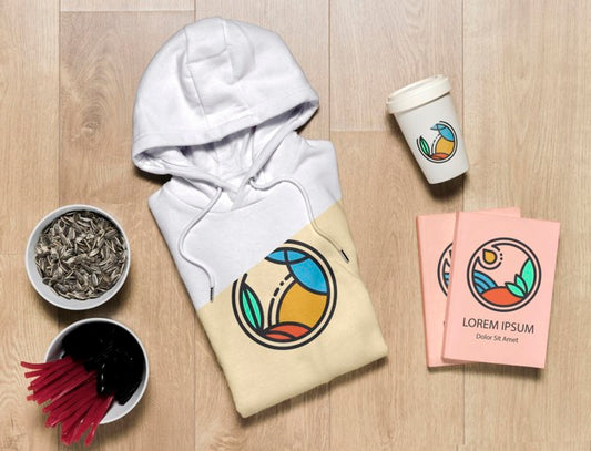 Free Top View Folded Hoodie Mock-Up With Notebooks, Cup And Sunflower Seeds Psd