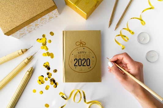 Free Top View Golden Notepad And Hand Psd