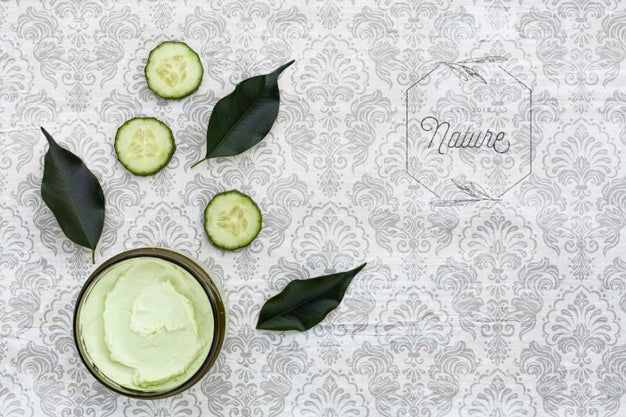 Free Top View Of Body Butter And Cucumber On Plain Background Mock-Up Psd