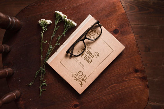Free Top View Of Book On Chair With Flowers And Glasses Psd