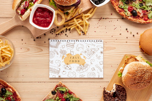 Free Top View Of Fast Food On Wooden Table With Notebook Mock-Up Psd