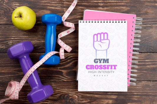 Free Top View Of Fitness Notebook With Apple And Weights Psd