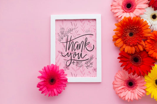 Free Top View Of Frame And Flowers With Pink Background Psd