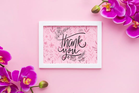 Free Top View Of Frame Mock-Up And Flowers On Pink Background Psd