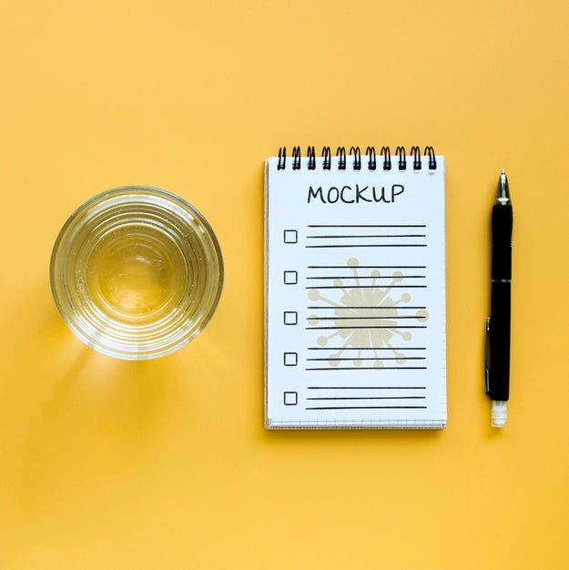 Free Top View Of Glass Of Water With Notebook And Pen Psd