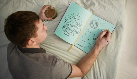 Free Top View Of Man Writing In Notebook On Bed Psd
