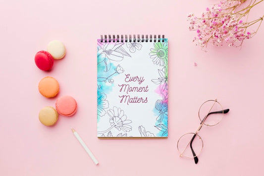 Free Top View Of Notebook With Flowers And Macarons Psd