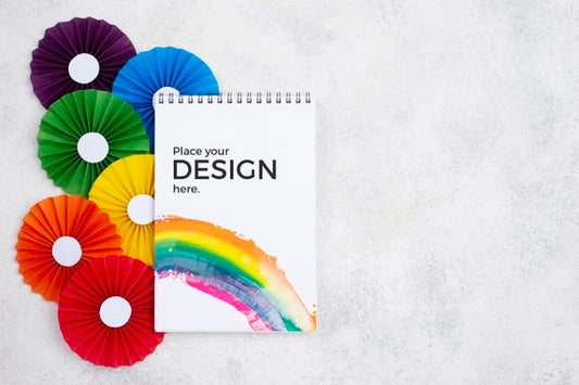 Free Top View Of Rainbow Colored Rosettes And Notebook Psd