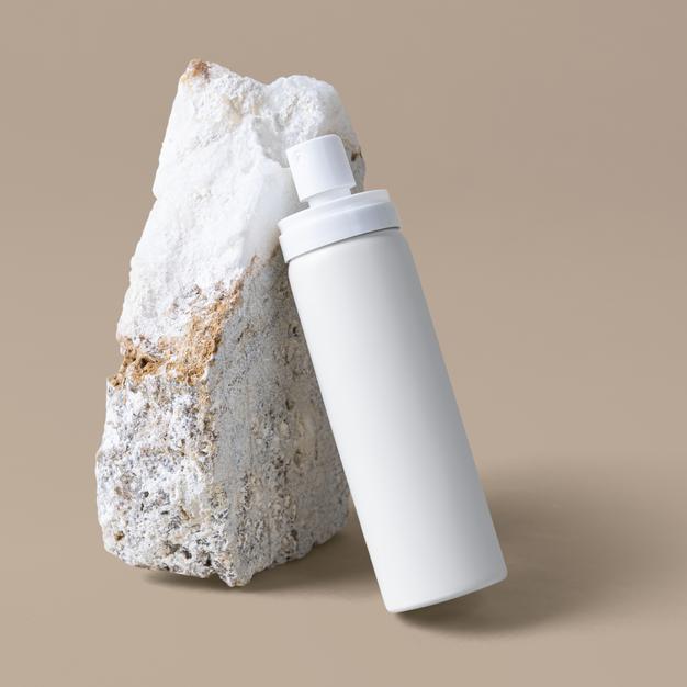 Free White Spray Bottle Mockup Against A Rock Psd
