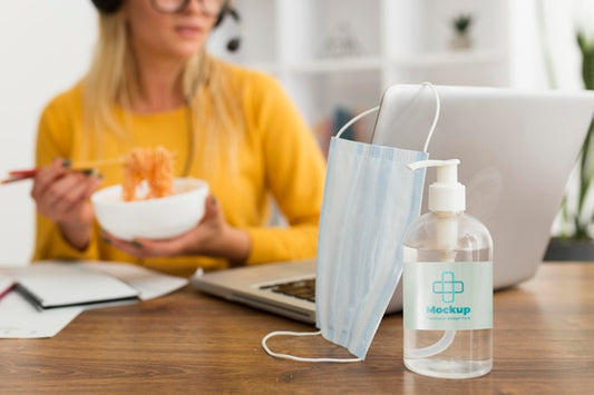 Free Woman Eating At Desk With Disinfectant Mock-Up Psd