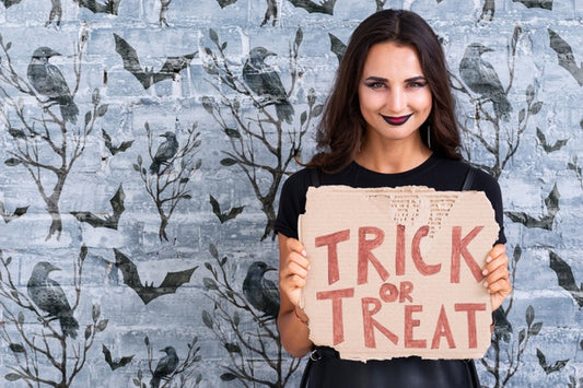 Free Woman Holding A Card With Trick Or Treat Lettering Psd