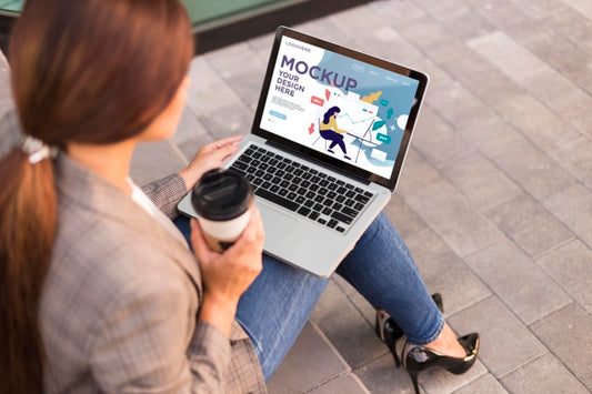 Free Woman Holding A Mock-Up Laptop Outdoors Psd