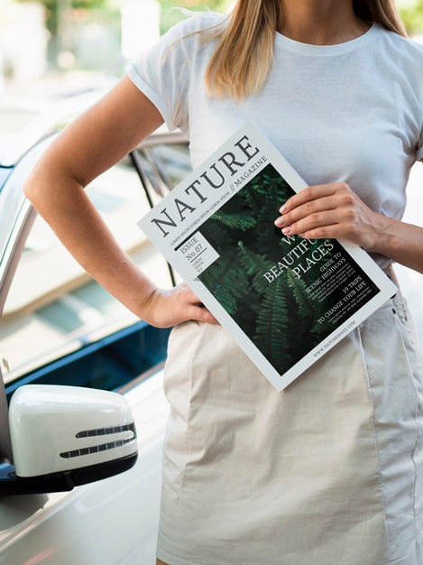 Free Woman Holding A Nature Magazine Next To A Car Psd