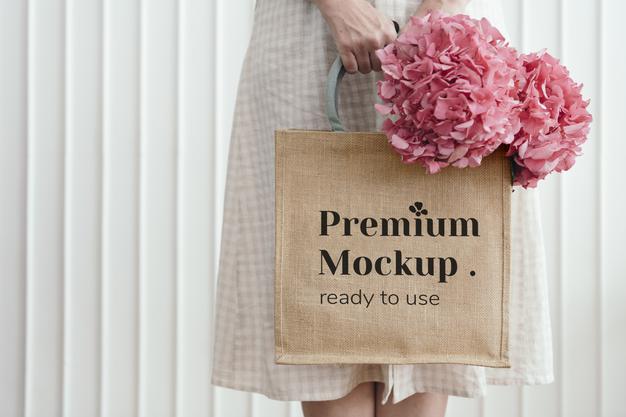Free Woman Holding A Woven Tote Bag Mockup With Pink Hydrangea Flowers Psd