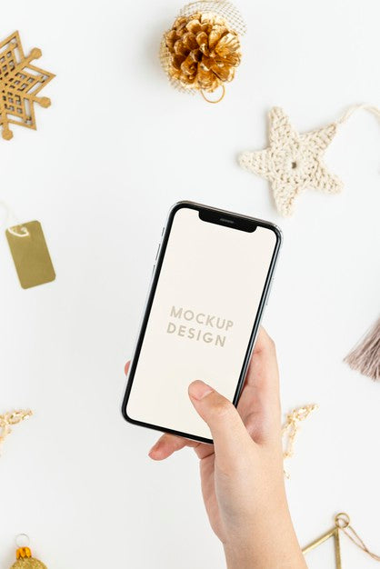 Free Woman Holding Her Phone Above Gold Christmas Ornaments Mockup Psd
