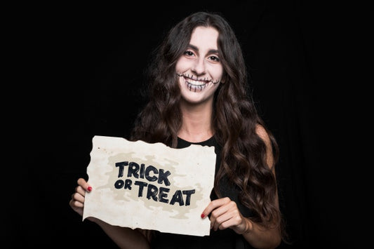 Free Woman Holding Paper With Halloween Lettering Psd