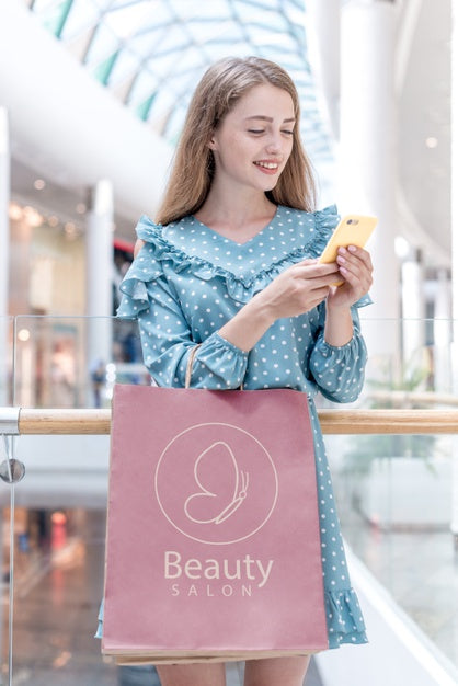Free Woman Looking At Her Phone In Shopping Mall Psd