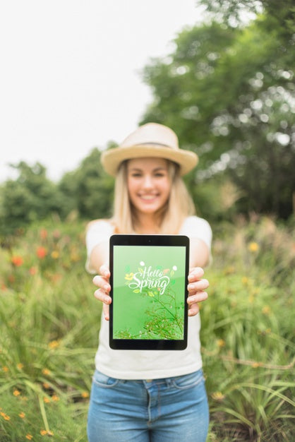 Free Woman Presenting Tablet Mockup In Nature Psd