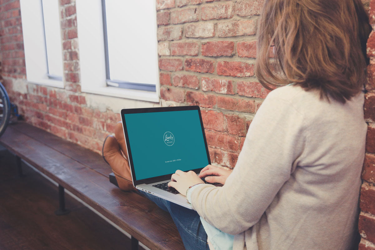 Free Woman Sitting with Macbook on Her Knees PSD Mockup