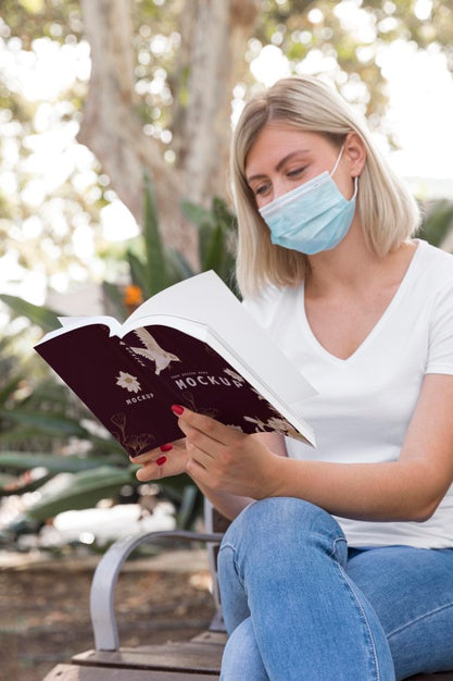 Free Woman Wearing Mask On Street Reading Book Psd