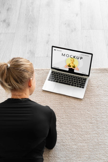 Free Yoga Instructor Looking At A Laptop Mock-Up Psd