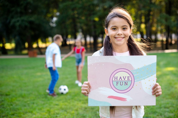 Free Young Girl In Park Holding Sign With Positive Message Psd